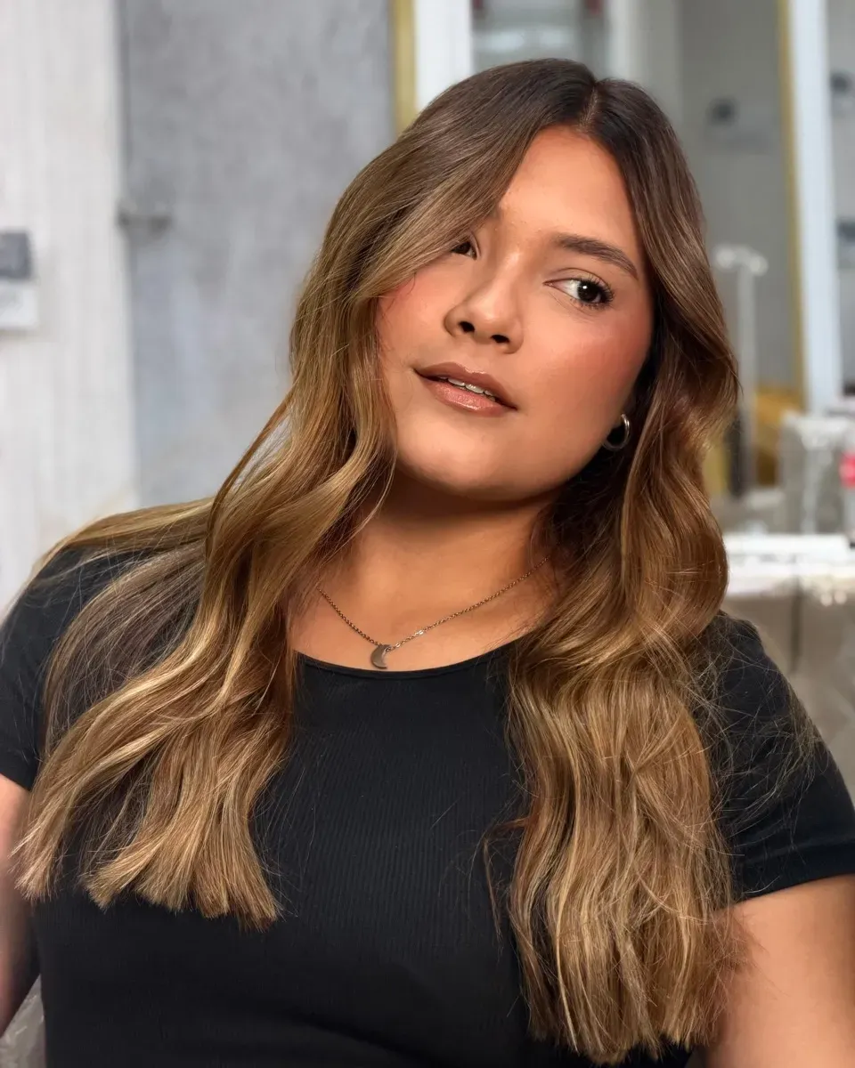After: the same client with her finished balayage, long hair in honey tones.